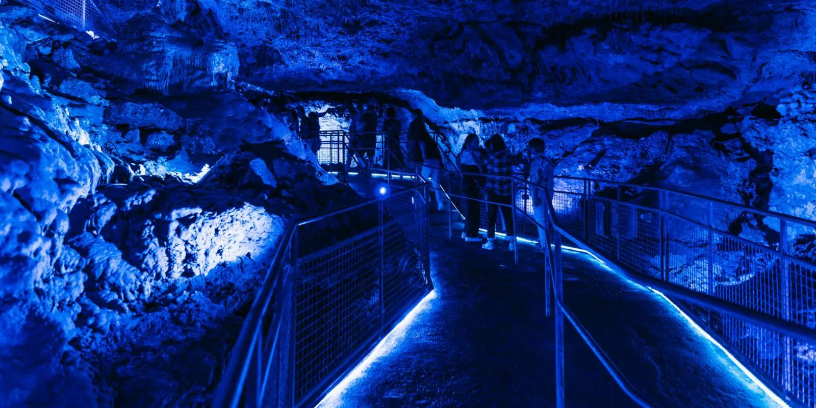 Caves of Hams blue-lit walkway with stalactites lining the path — Mallorca