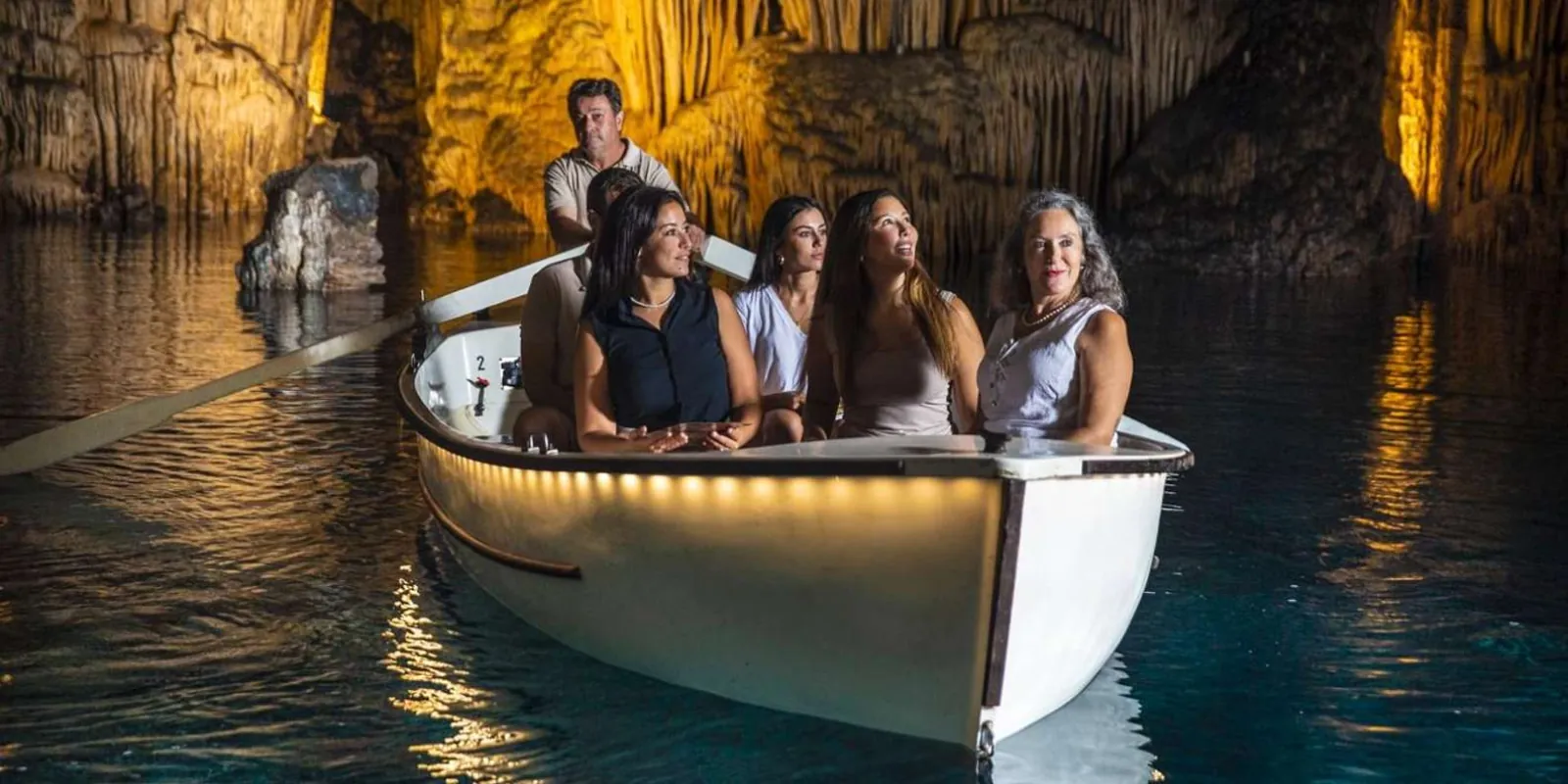 Caves of Hams wooden boat carrying guests across the Sea of Venice underground lake — Mallorca