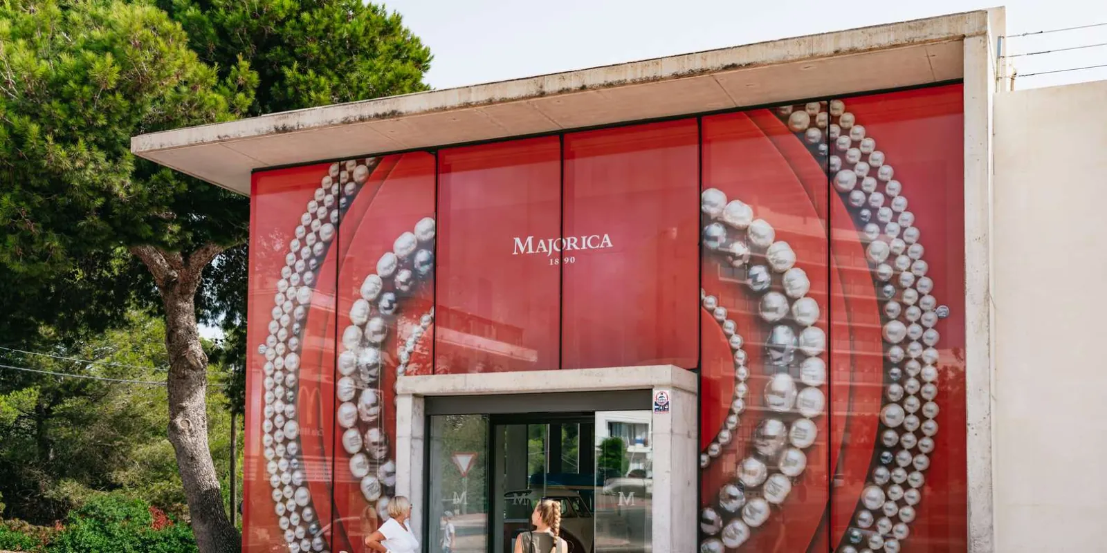 Majorica pearl shop exterior with signature red facade and pearl necklace display — Mallorca